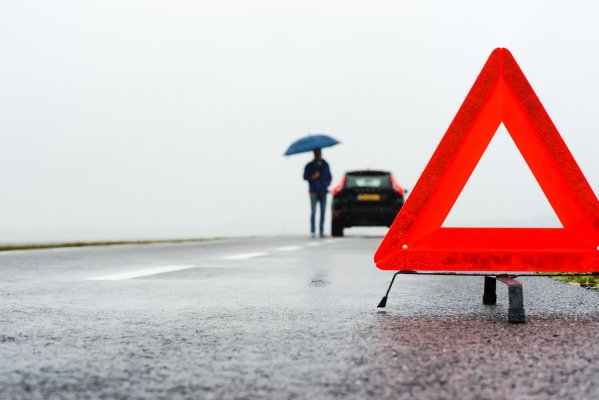 extended car warranty services protect my car car breakdown man with umbrella on the side of the road red triangle